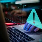 Digital warning alert on a laptop screen for letting agents' cybersecurity.