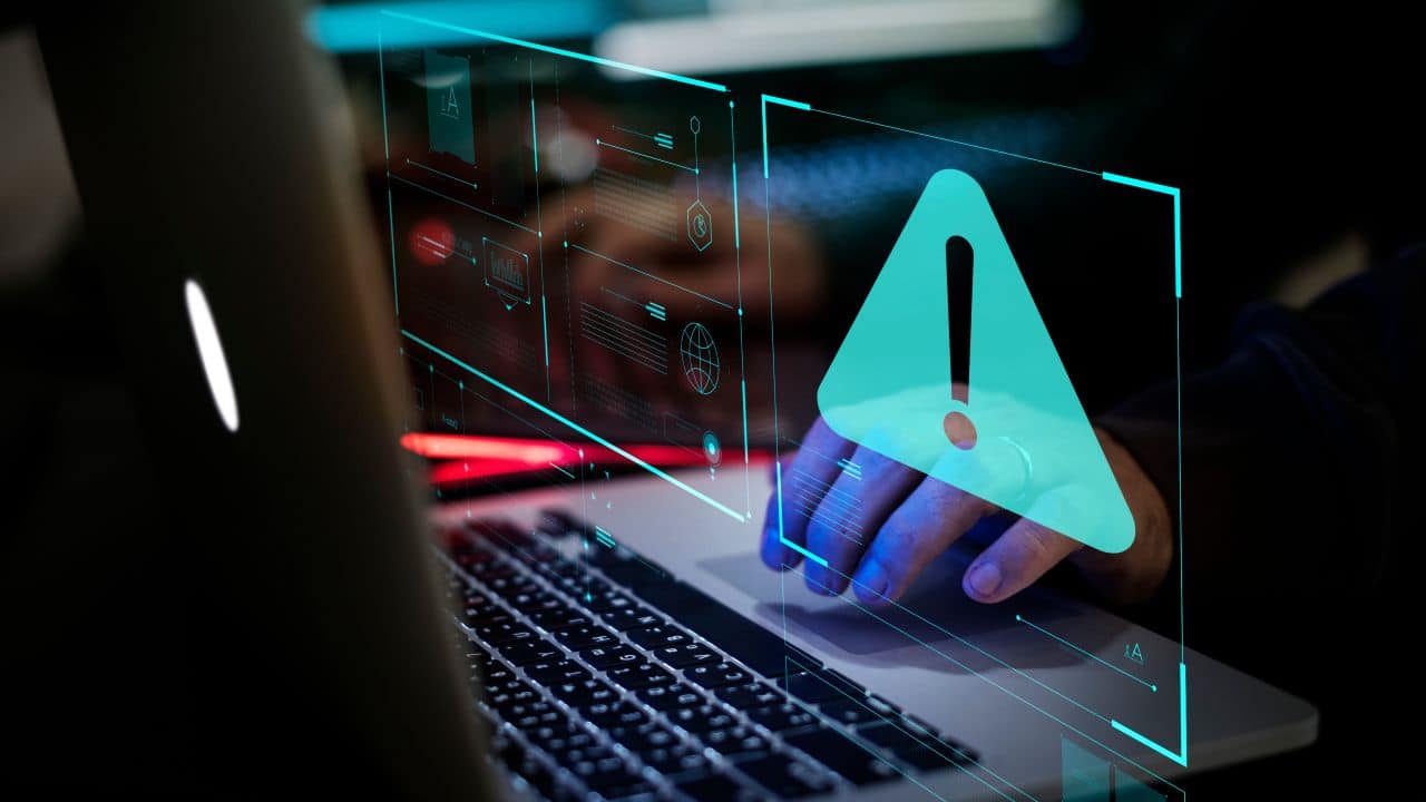 Digital warning alert on a laptop screen for letting agents' cybersecurity.