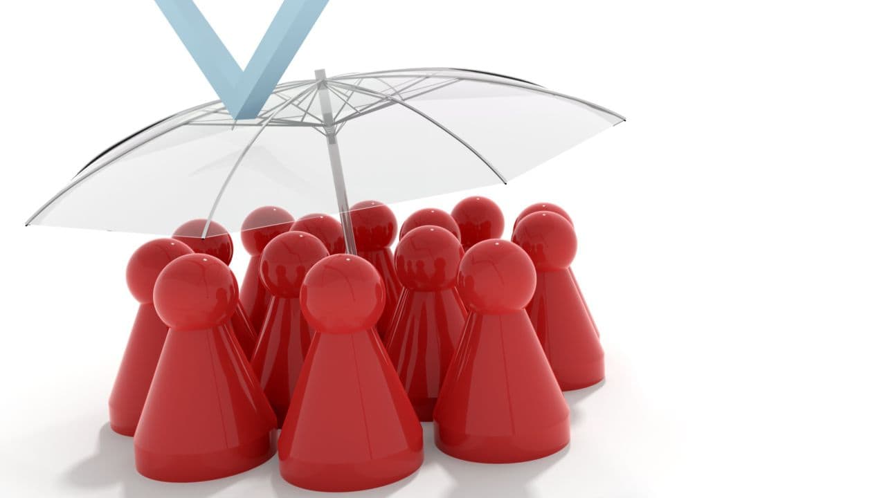 Red game pieces under a transparent umbrella symbolising protection in property management.
