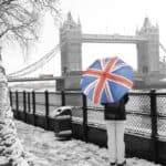 Person with Union Jack umbrella by Tower Bridge in winter.