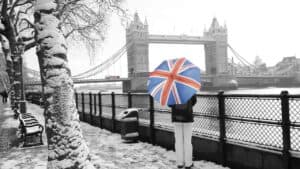 Person with Union Jack umbrella by Tower Bridge in winter.