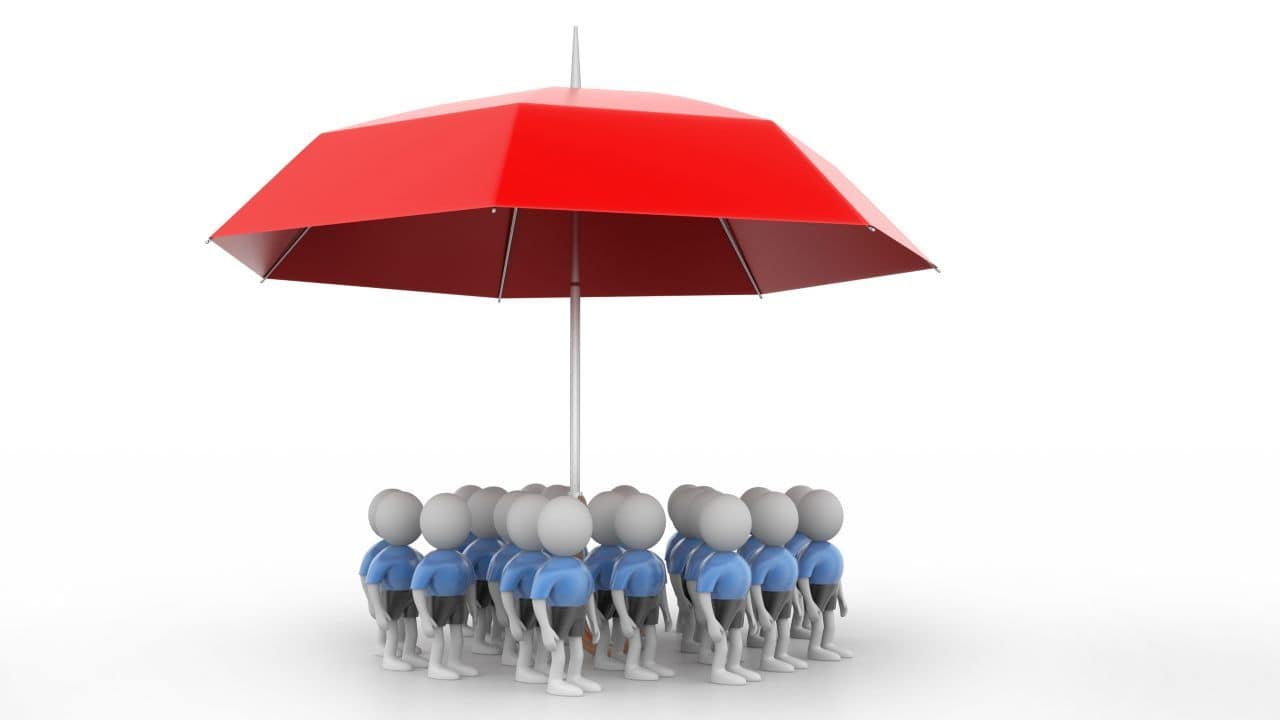 Miniature figures under a red umbrella symbolising protection or teamwork.