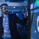 Businessman analyzing digital market data on large screen.