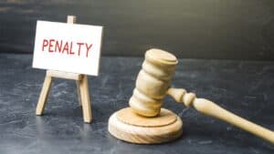 Gavel and penalty notice sign representing legal enforcement in property management.