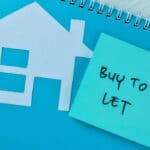House icon and 'Buy to Let' sticky note on a desk.