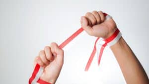 Two hands breaking a red and white striped ribbon symbolising success in letting.