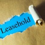 Torn paper revealing the word Leasehold on a brown background.