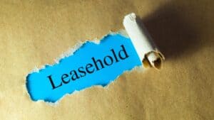 Torn paper revealing the word Leasehold on a brown background.